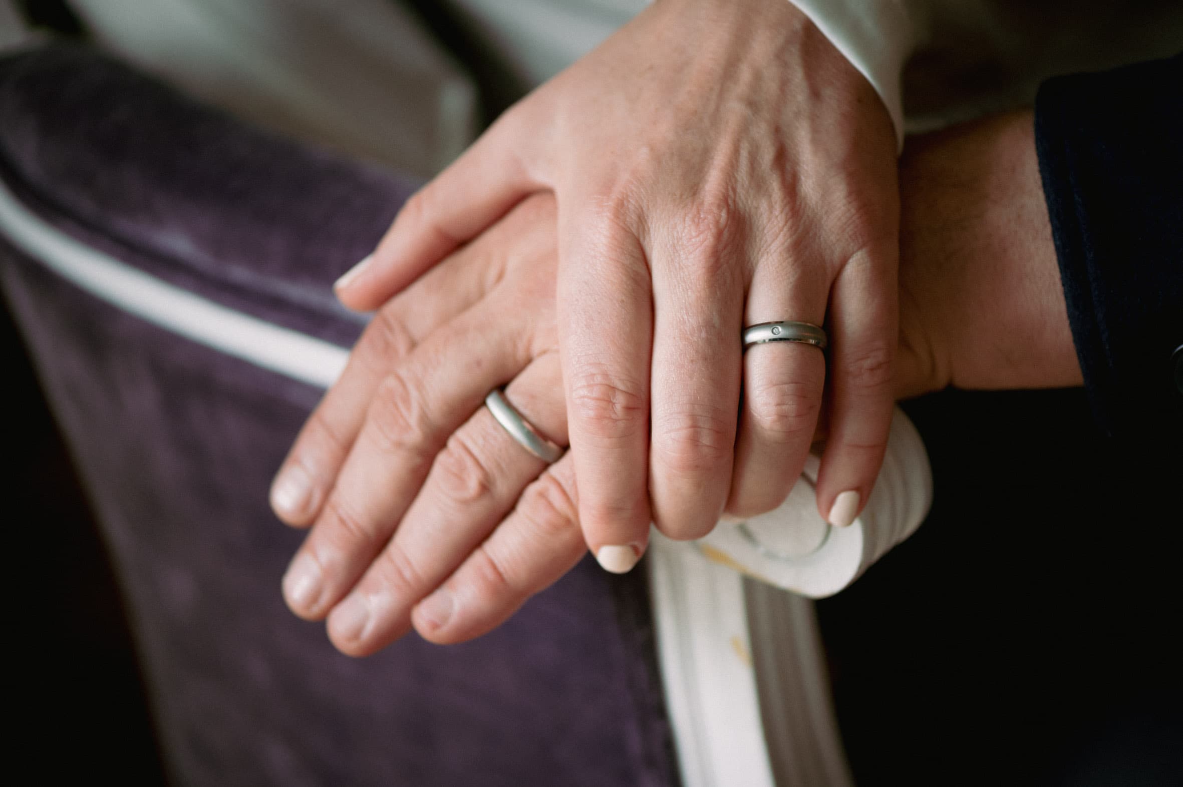 Historische Schwarzweißaufnahme eines jungen Paares im Freien, eng nebeneinanderstehend, als Symbol für familiäre Tradition und Herkunft , Übereinandergelegte Hände eines Paares mit schlichten Titanringen von ReWi Titan, getragen im Alltag als Zeichen von Verbundenheit und Beständigkeit